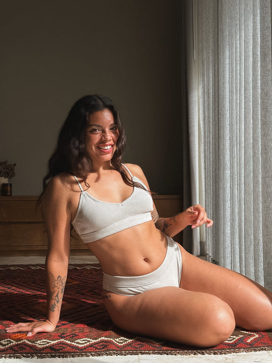 Woman sitting on a rug indoors, wearing a sports bra and shorts Cotton Set Love Child Bali.
