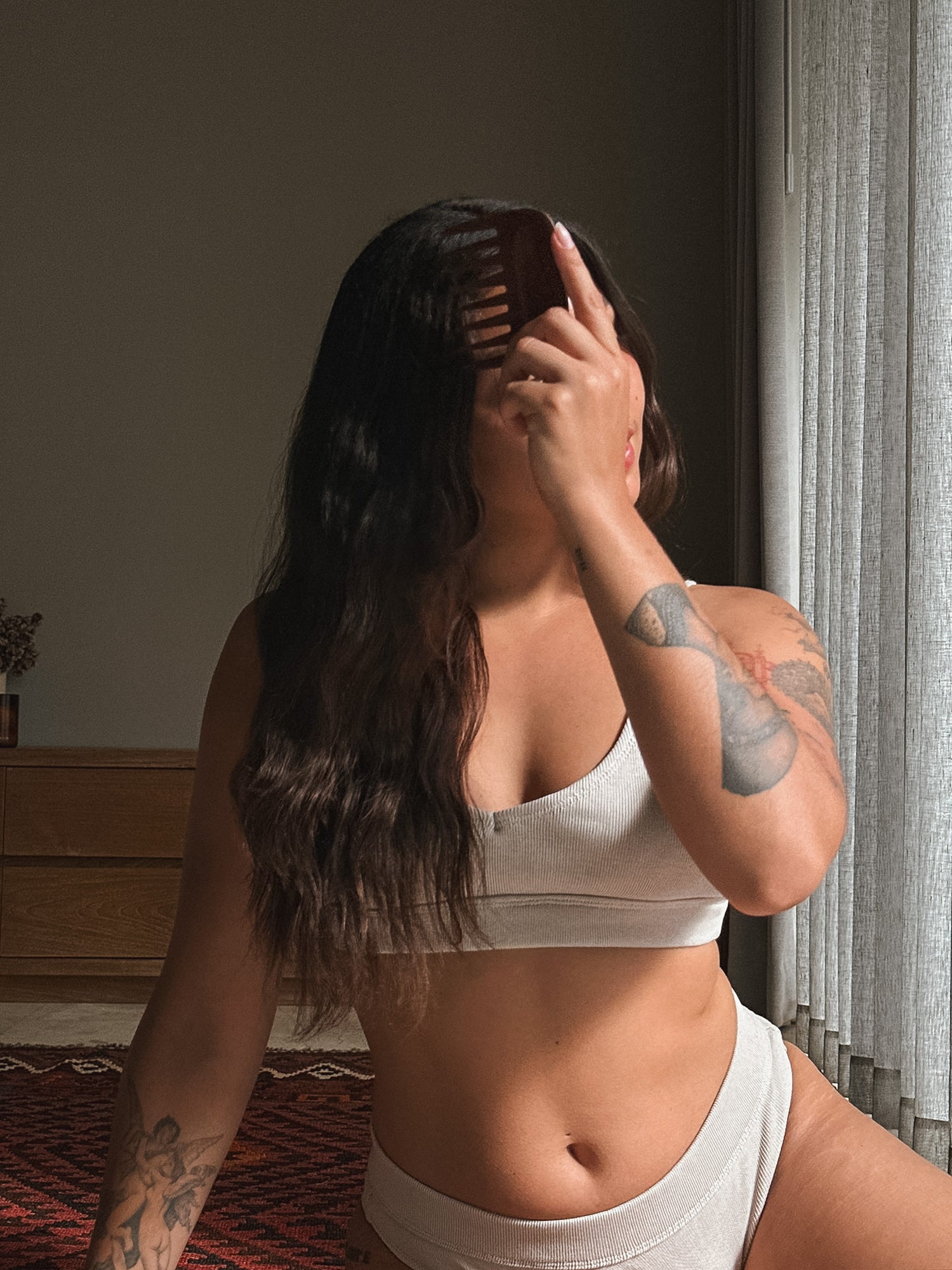 Woman in a white bra and underwear Cotton Set Love Child Bali standing in a room with a window.